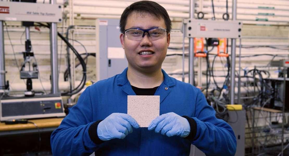 Yinjian (Klay) Li, studente del master in Ingegneria strutturale e Meccanica, tiene in mano un campione di prova in polimero rinforzato con fibre che viene preparato per le prove di fatica a trazione, come parte della ricerca condotta dal professor Michael Lepech. Le macchioline sulla superficie del campione aiutano i ricercatori a misurare digitalmente la deformazione durante il test.