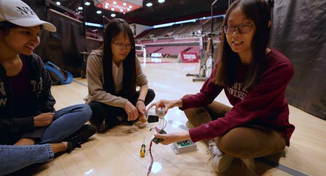 La professoressa Hae Young Noh (al centro), con le studentesse laureate Sulagna Sarkar (a sinistra) e Yiwen Dong (a destra), assemblano i sensori prima di installarli al Maples Pavilion.