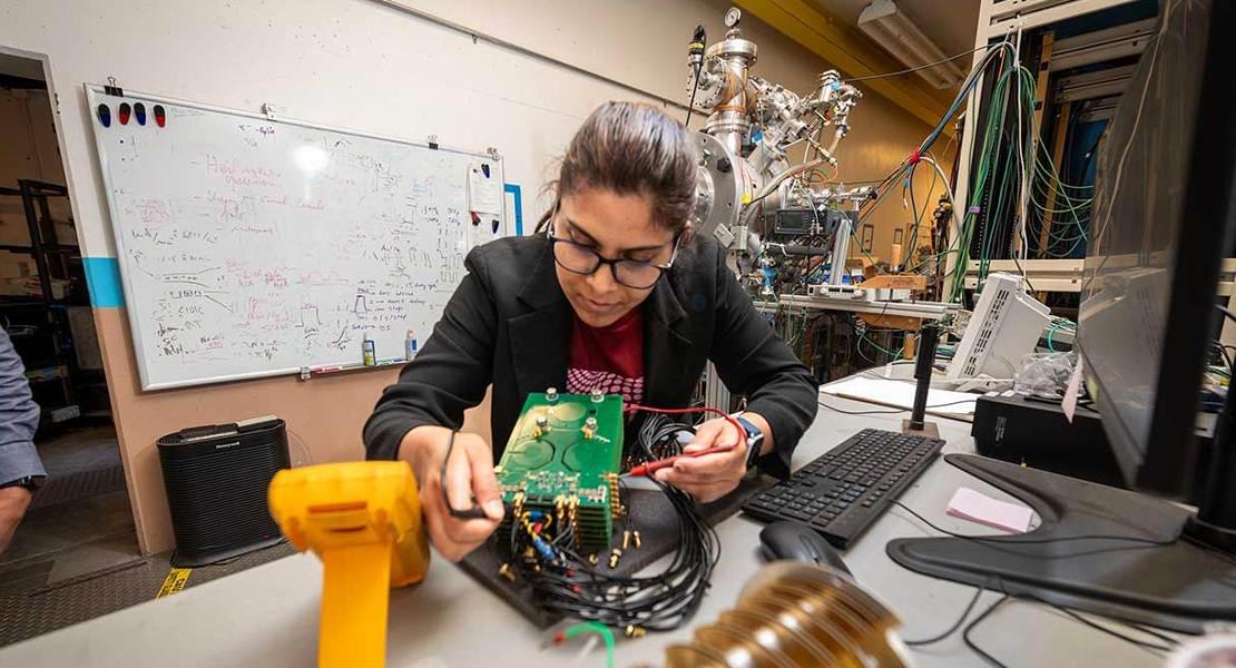 Kaushalya Jhuria in laboratorio testa l'elettronica che fa parte dell'apparato sperimentale utilizzato per realizzare qubit in silicio.