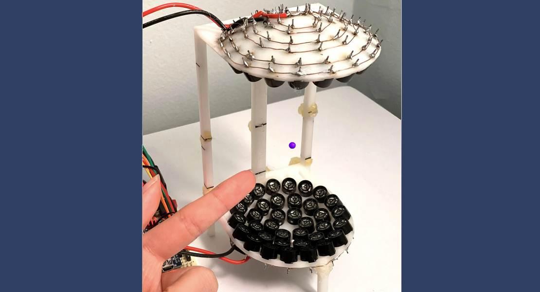 I ricercatori di fisica della New York University hanno osservato un nuovo tipo di cristallo temporale, le cui particelle levitano su un cuscino sonoro mentre interagiscono tra loro scambiando onde sonore. Sopra, una perla (viola) è sospesa a mezz’aria dalle onde sonore emanate da altoparlanti circolari (neri) disposti in una cornice stampata in 3D alta sei pollici.